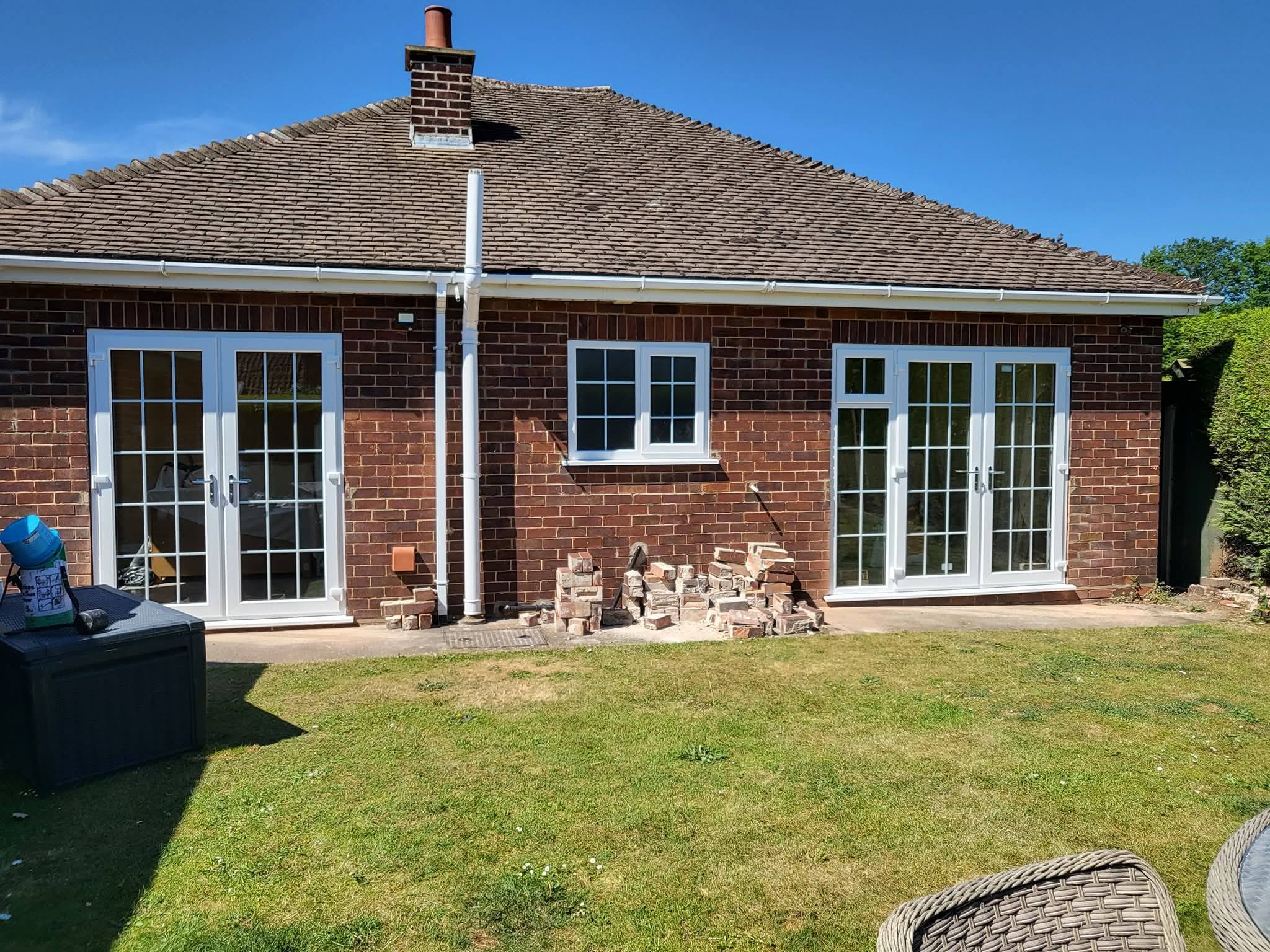 White uPVC French doors and casement windows on rear of bungalow